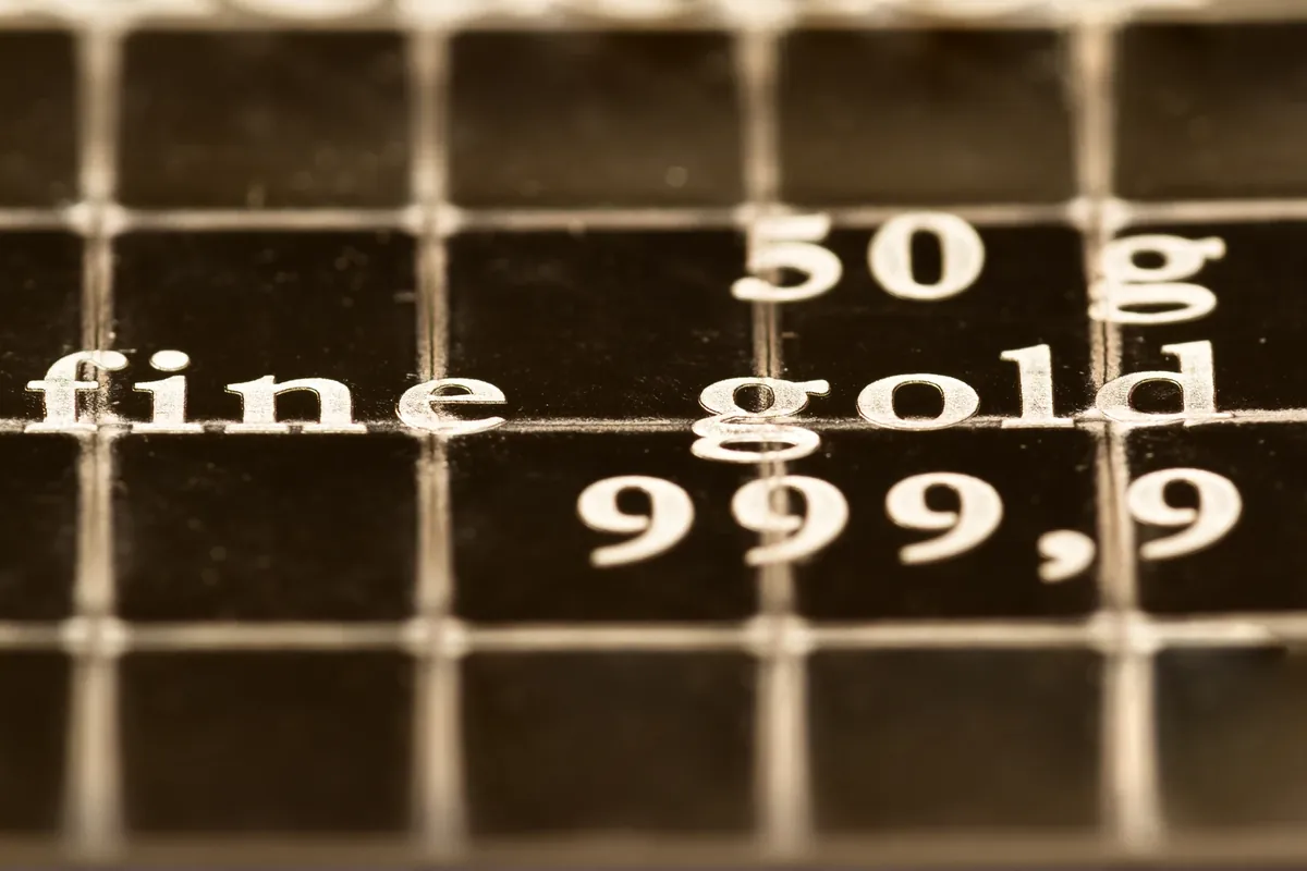 Close-up of the stamped purity mark 'fine gold 999.9' on a gold bar